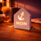 Keramik-Hafenhäuschen – Motiv „Moin“ beleuchtet bei Nacht